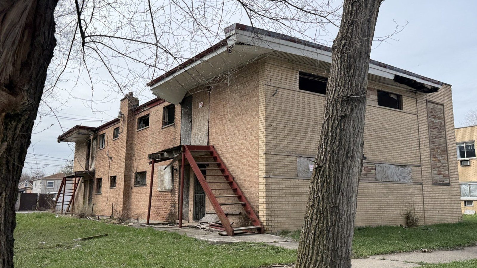 A boarded-up dilapidated brick apartment building in Harvey, Illinois