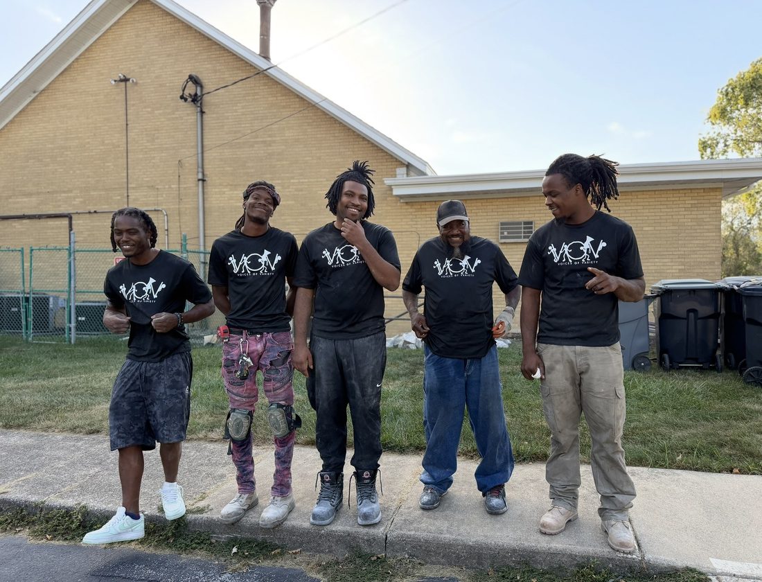 Five V.O.V crew members in matching shirts after a work day