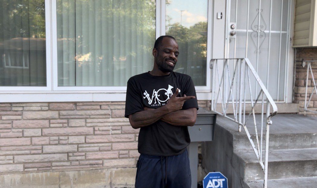 A V.O.V member pointing to his shirt on a client&rsquo;s porch
