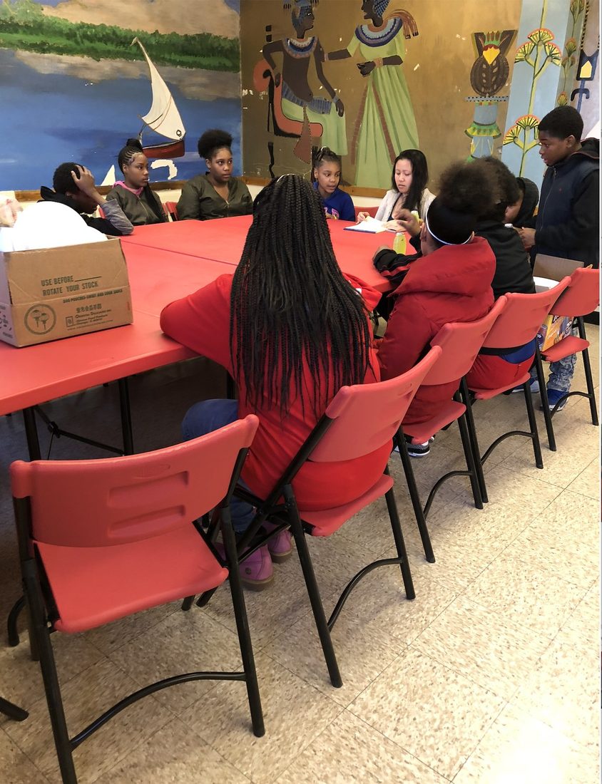 V.O.V teens around the tables at a community center program