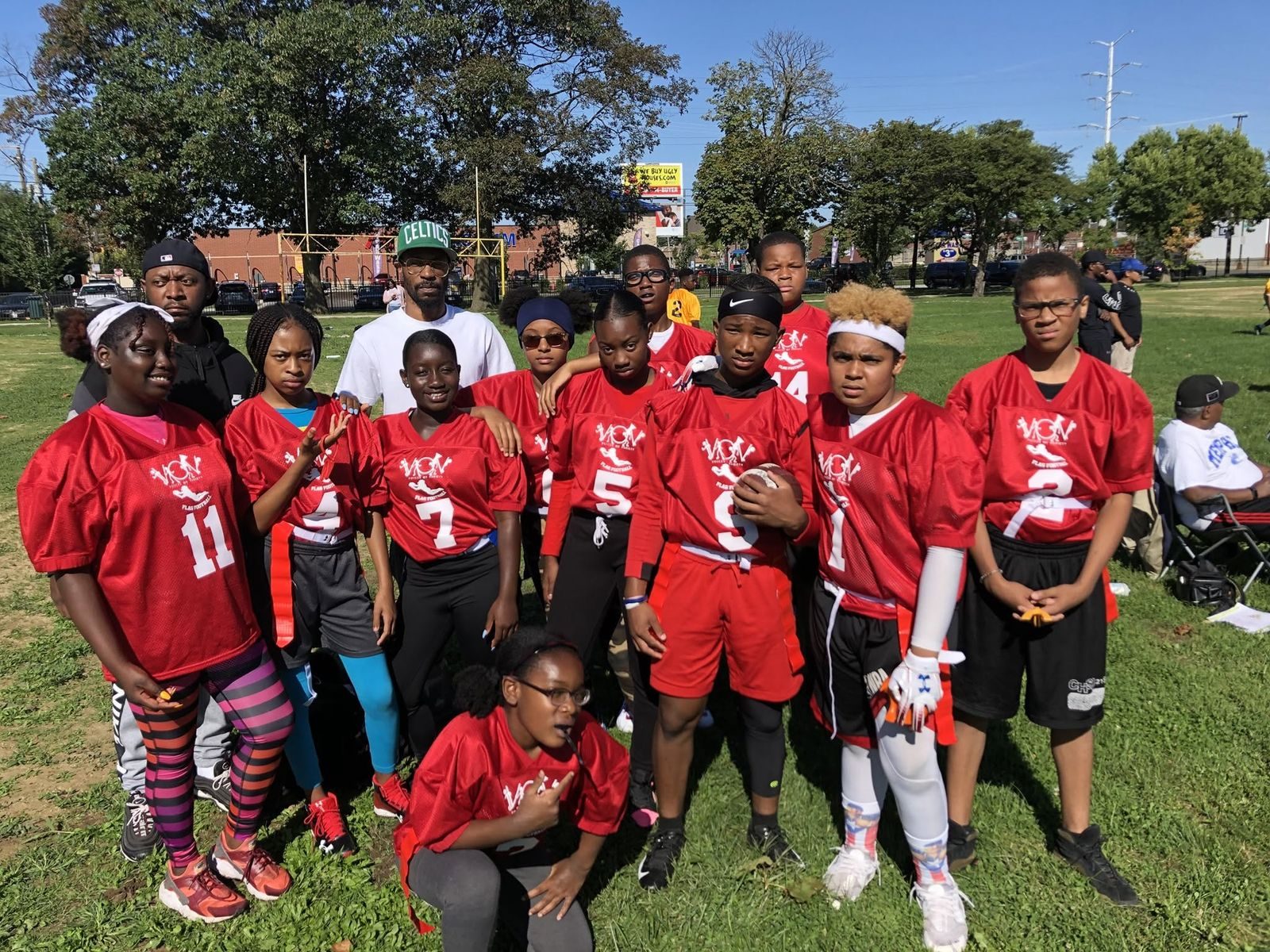The V.O.V flag football team in red jerseys with their coaches