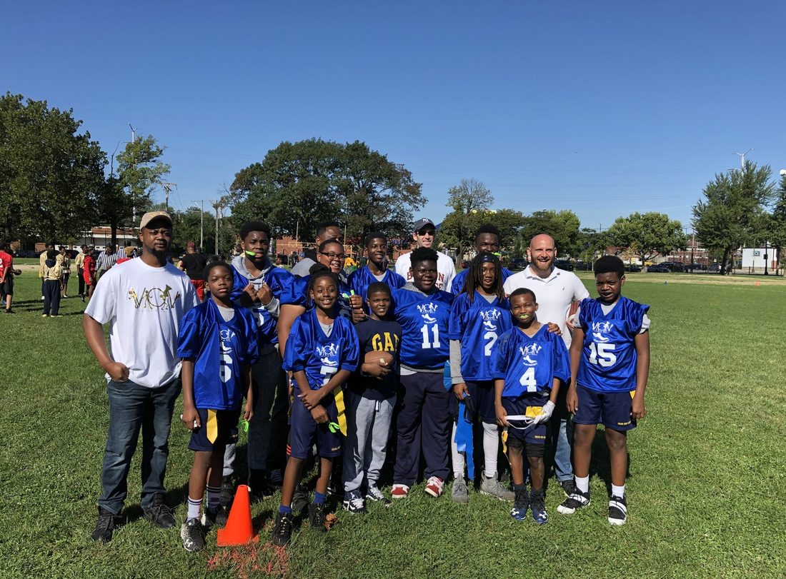 V.O.V flag football team in blue jerseys with their coaches