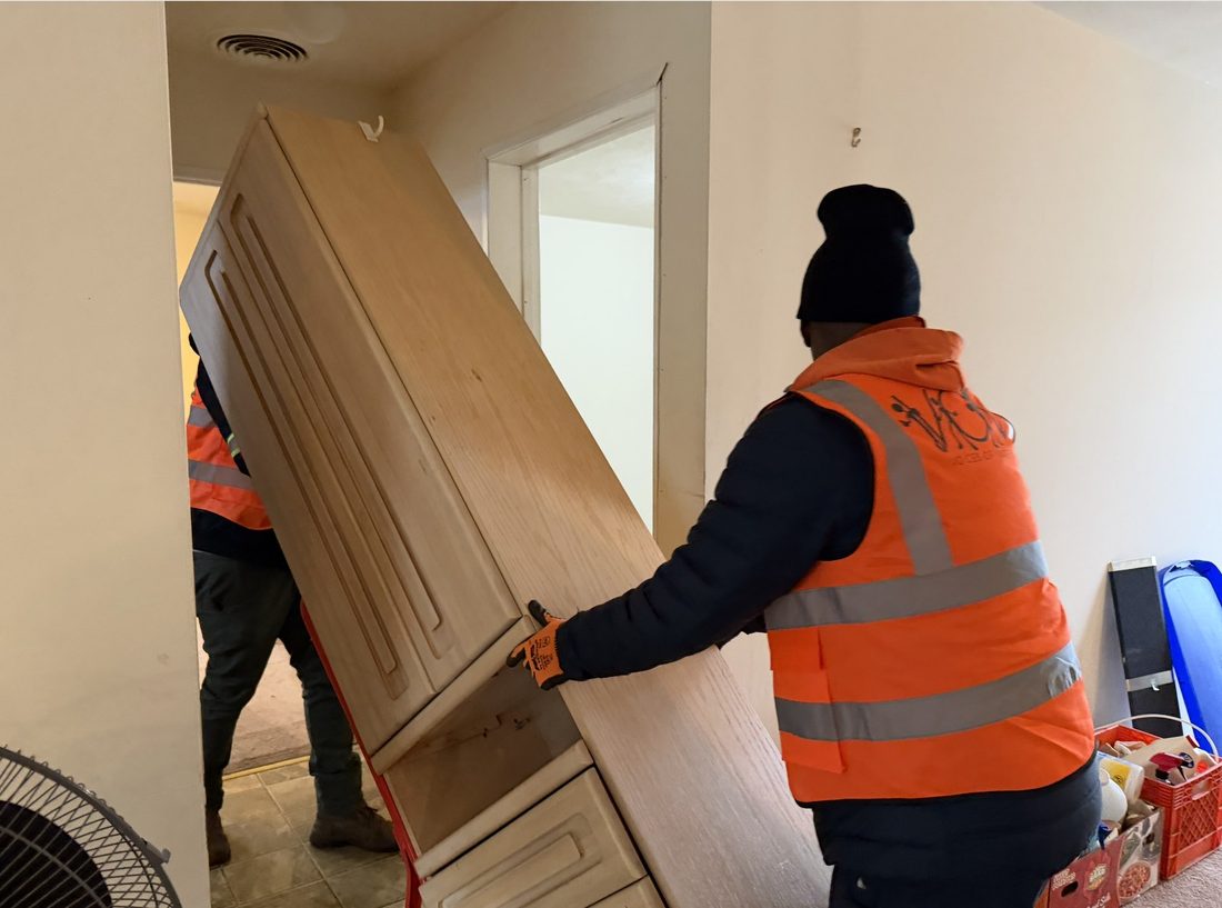 V.O.V crew carrying a cabinet through a doorway