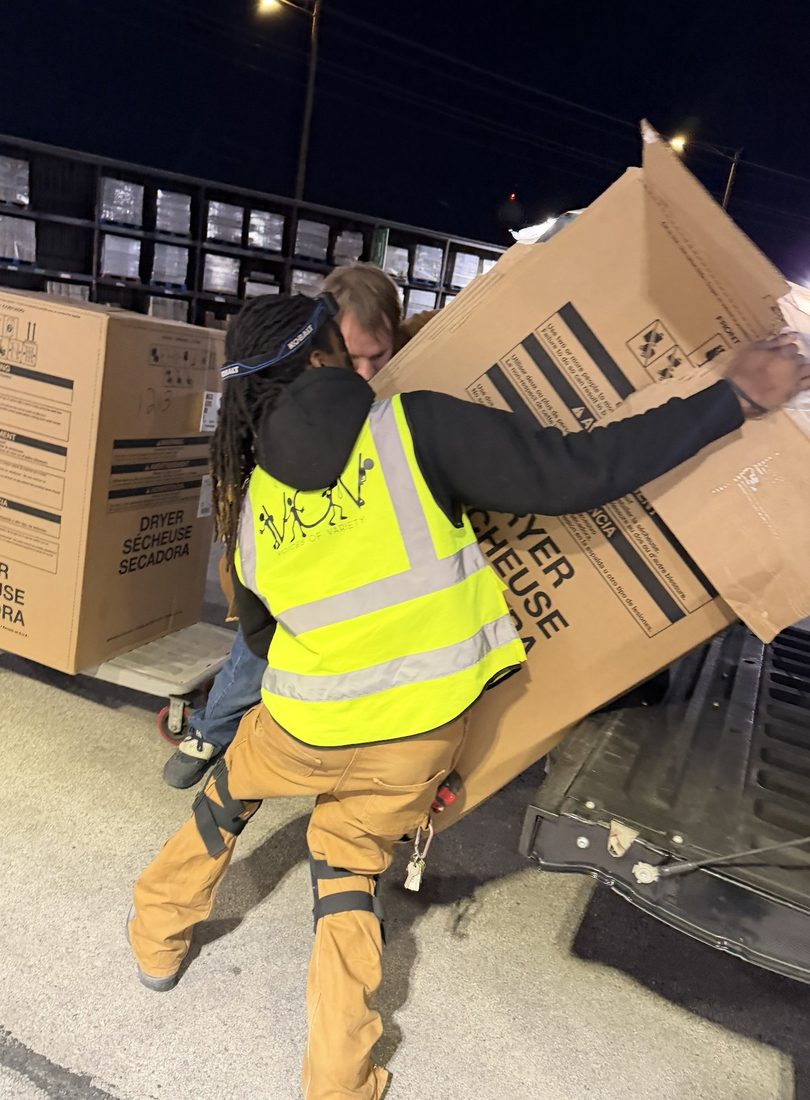 V.O.V worker loading appliance boxes at night