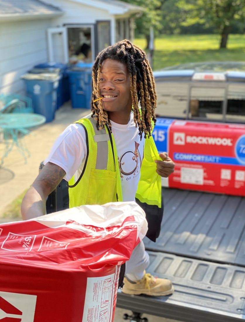 A young V.O.V workforce trainee loading insulation into a truck
