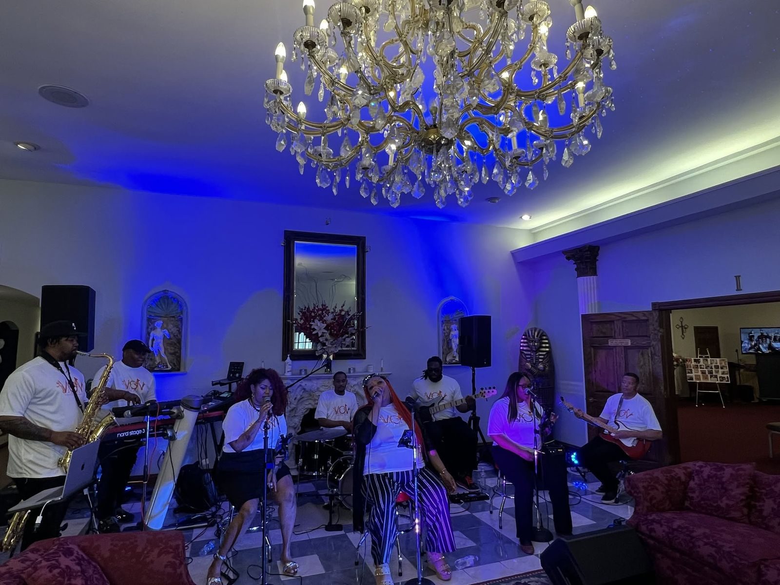 Live band performing at a V.O.V event under a chandelier