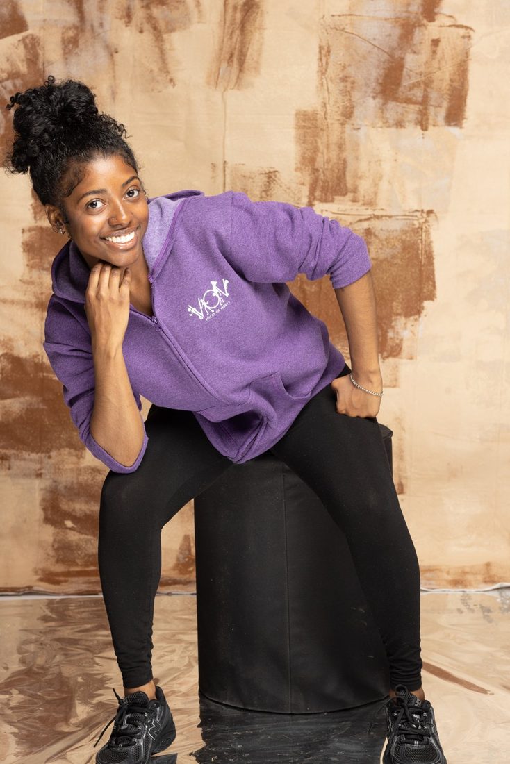 Model in the purple V.O.V zip hoodie with chest logo