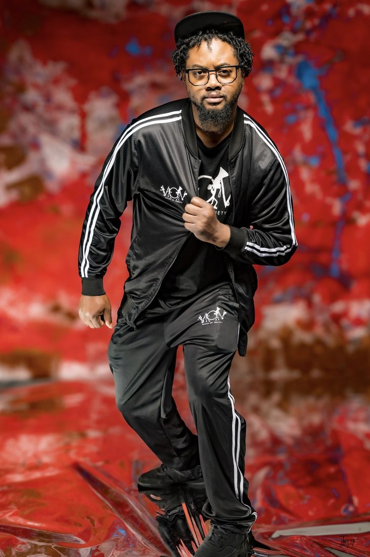 Model in the black V.O.V jogging suit with white stripes and chest logo