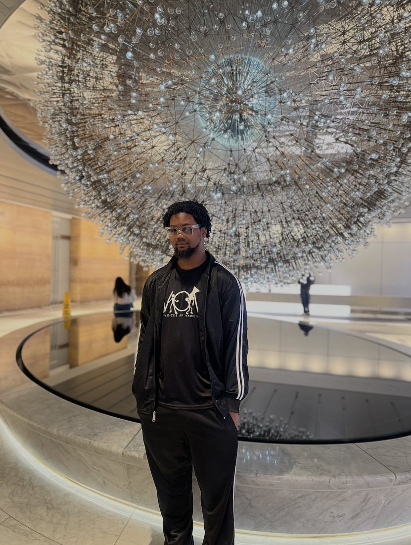 A V.O.V member on an exposure trip under a glass sculpture