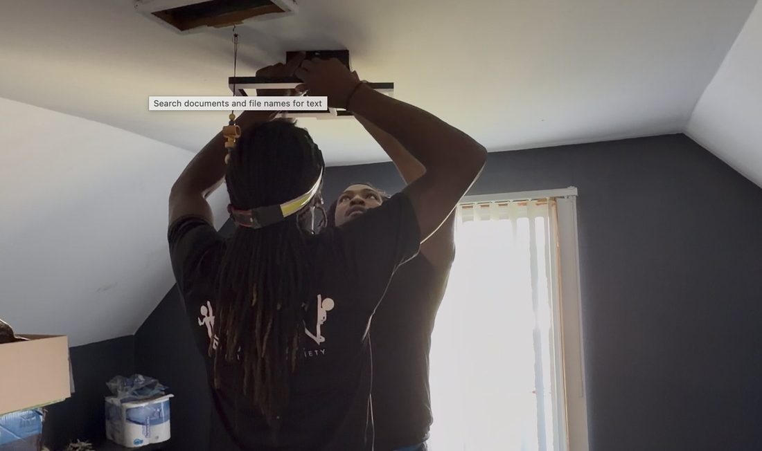 Two V.O.V members installing a new ceiling light