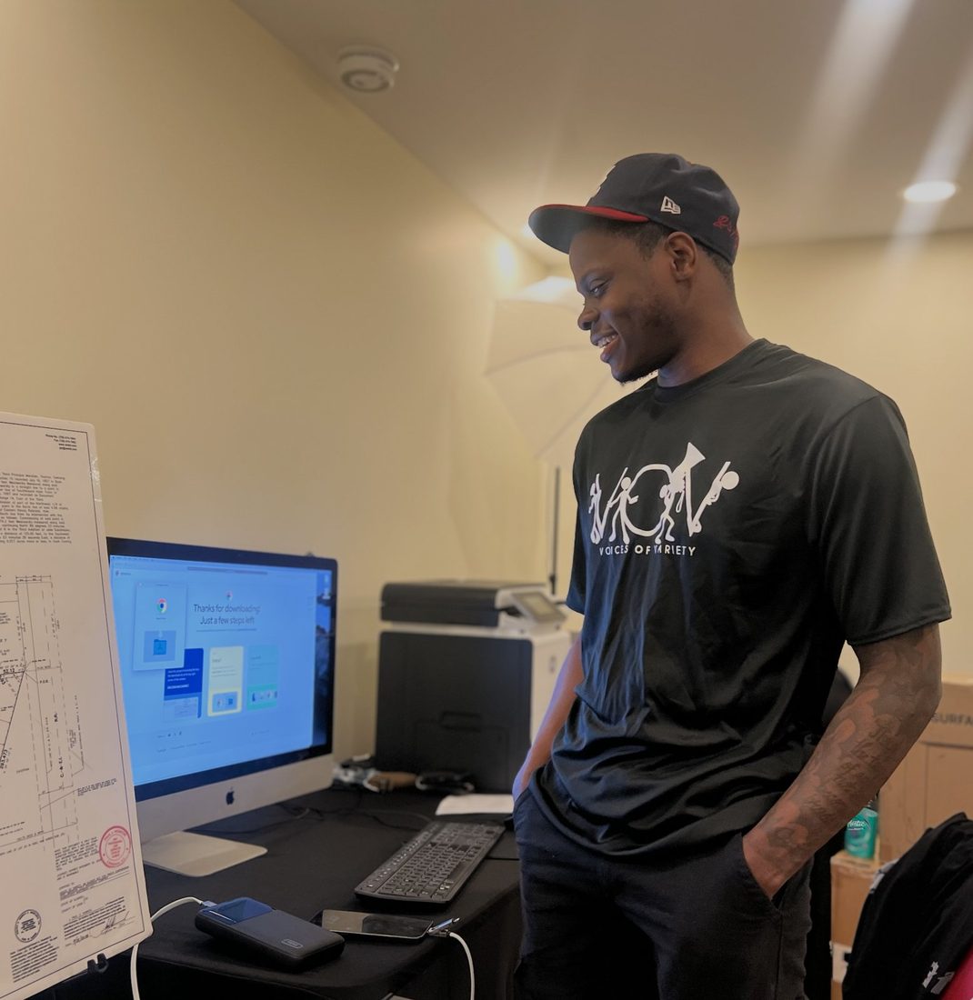 A V.O.V member smiling at the office tech station