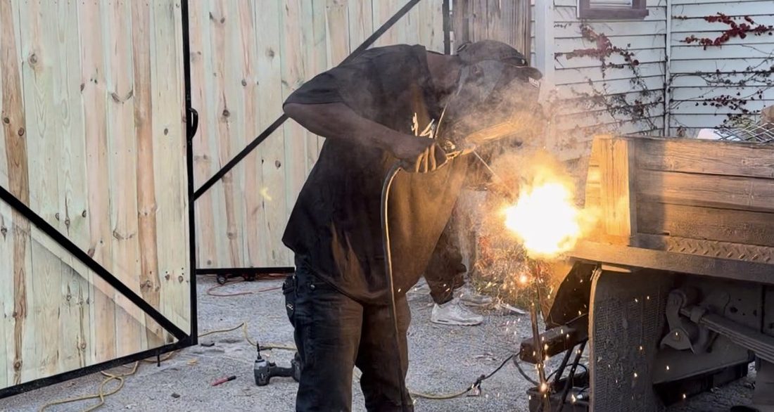 A V.O.V member welding a gate with sparks flying