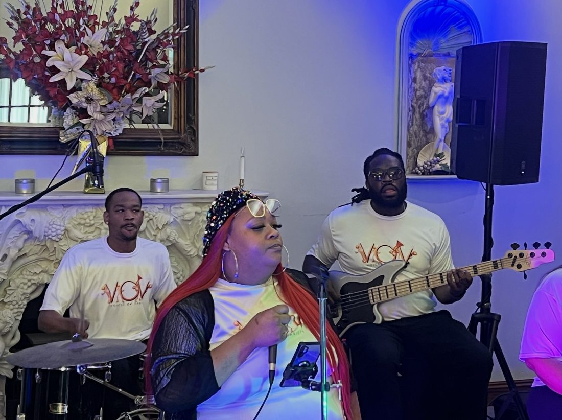 A V.O.V singer performing with the drummer and bassist