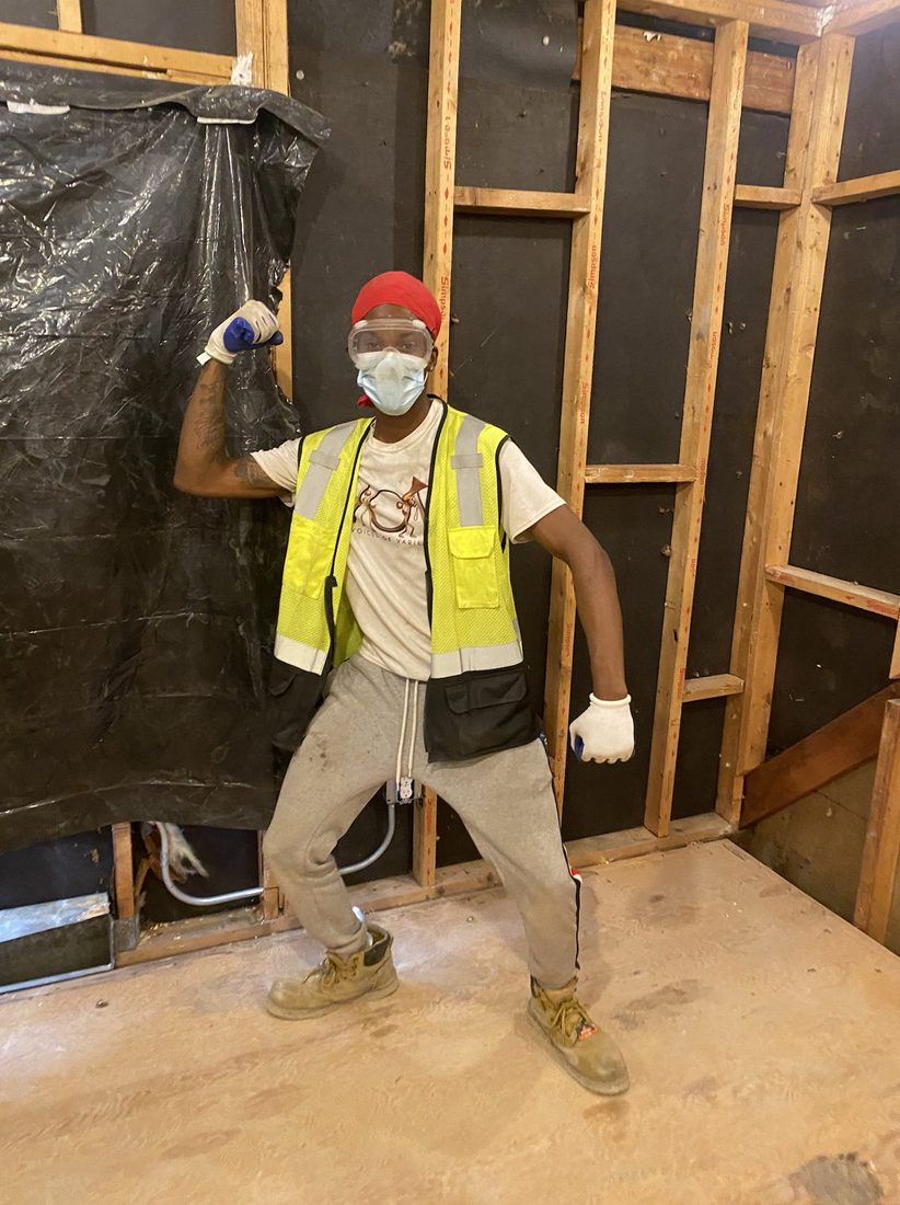 A V.O.V crew member flexing in full PPE on the demo site