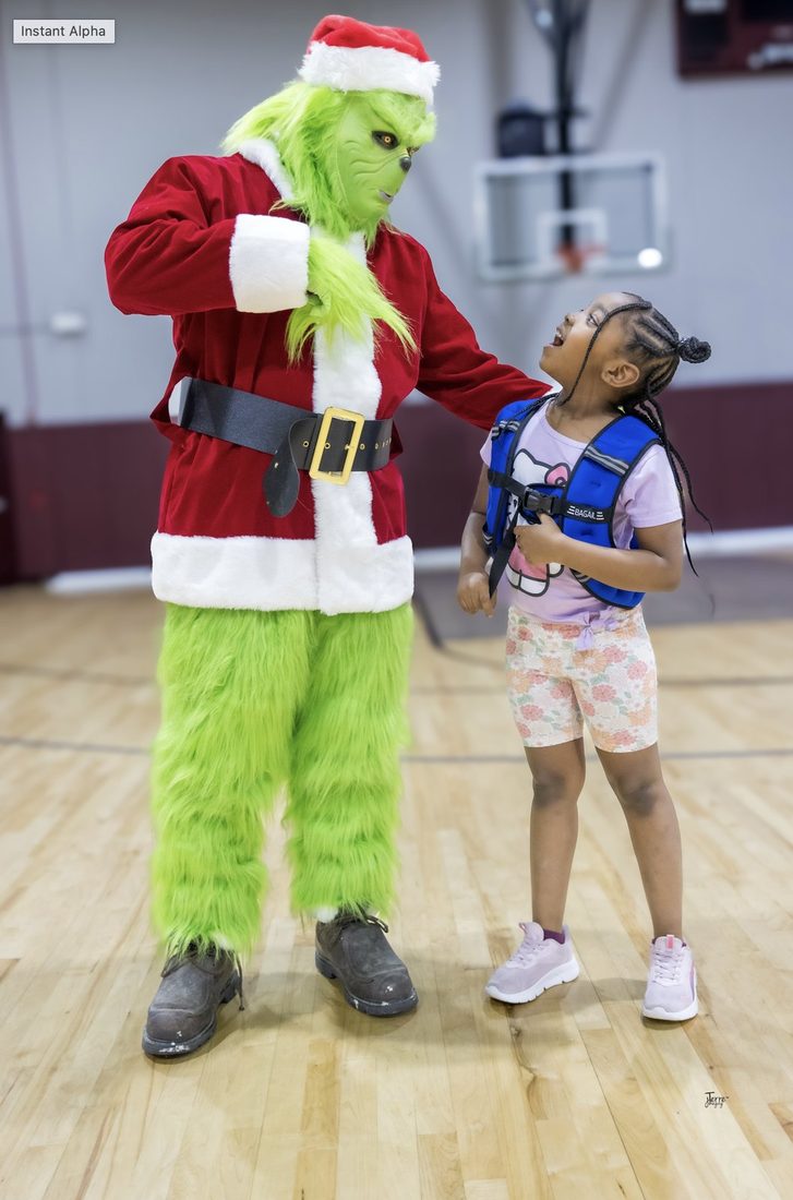 The Grinch greeting a young girl at a V.O.V holiday event