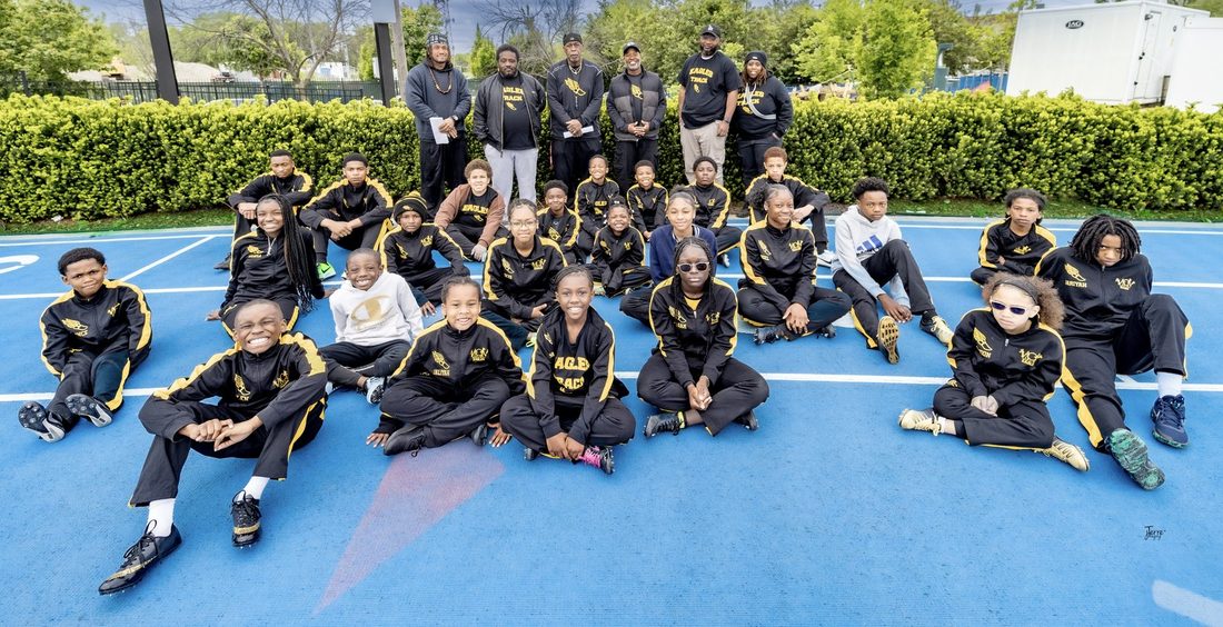 The V.O.V Eagles track team and coaches on the blue track