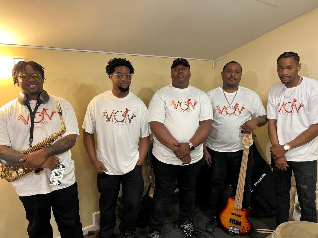 The V.O.V band in matching shirts with saxophone and bass
